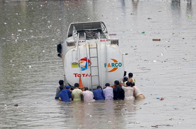 Men push a truck through a flooded road during monsoon rain in Karachi, Pakistan.  REUTERS/Akhtar Soomro  